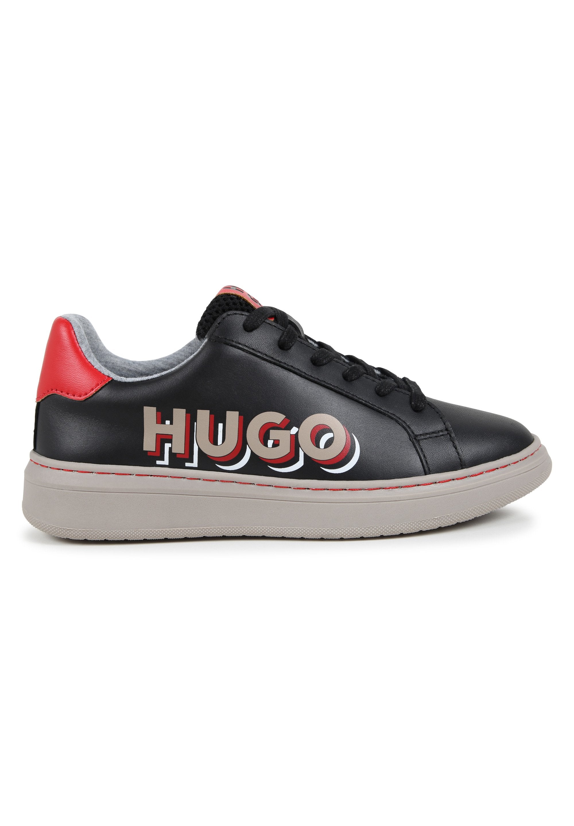 Schwarze Leder-Sneaker mit grauem Futter, roten Akzenten und prominentem "HUGO"-Logo in Weiß und Rot. Ausstattung mit flachen schwarzen Schnürsenkeln und strukturiertem Gummisole.