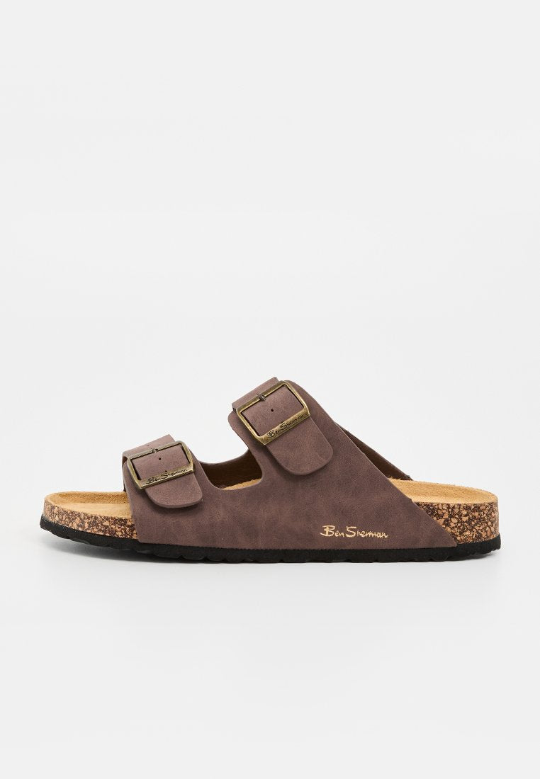 Braune offene Zehen-Slide-Sandale mit zwei verstellbaren Schnallenriemen und einem Korkfußbett mit schwarzer Sohle, seitlich mit dem Markennamen "Ben Sherman" versehen.