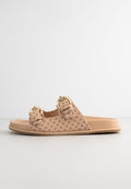 Beige Riemen-Sandale mit strukturiertem Stoffoberteil, ausgestattet mit doppelten Riemen und goldfarbenen Schnallen. Flache Sohle mit glatter Oberfläche.