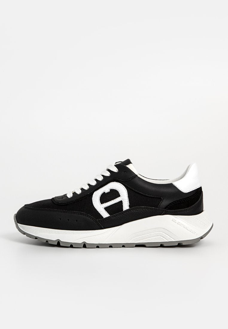 Schwarzer und weißer Sneaker aus Mesh und Leder. Verfügt über ein auffälliges Logo, kontrastierende Akzente und eine dicke Sohle mit strukturiertem Profil.