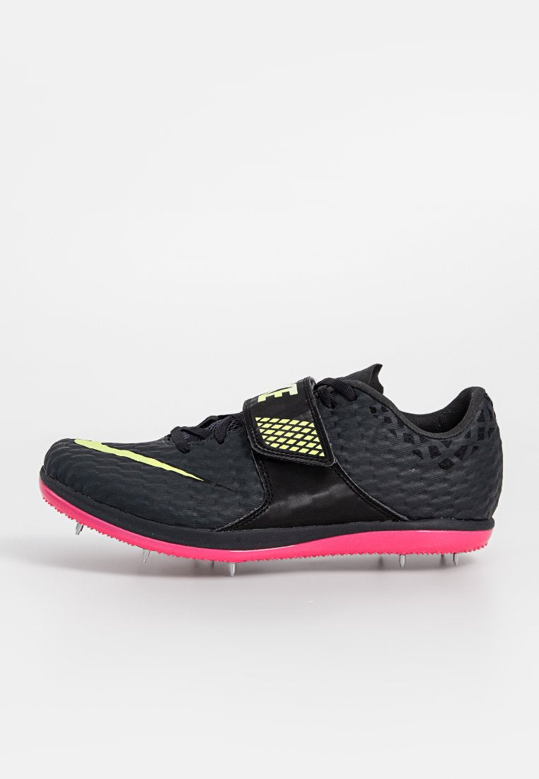 Schwarzer Sportschuh mit strukturiertem Obermaterial, gelben Akzenten, verstellbarem Riemen, rosa Sohle und Metallstollen für besseren Halt.