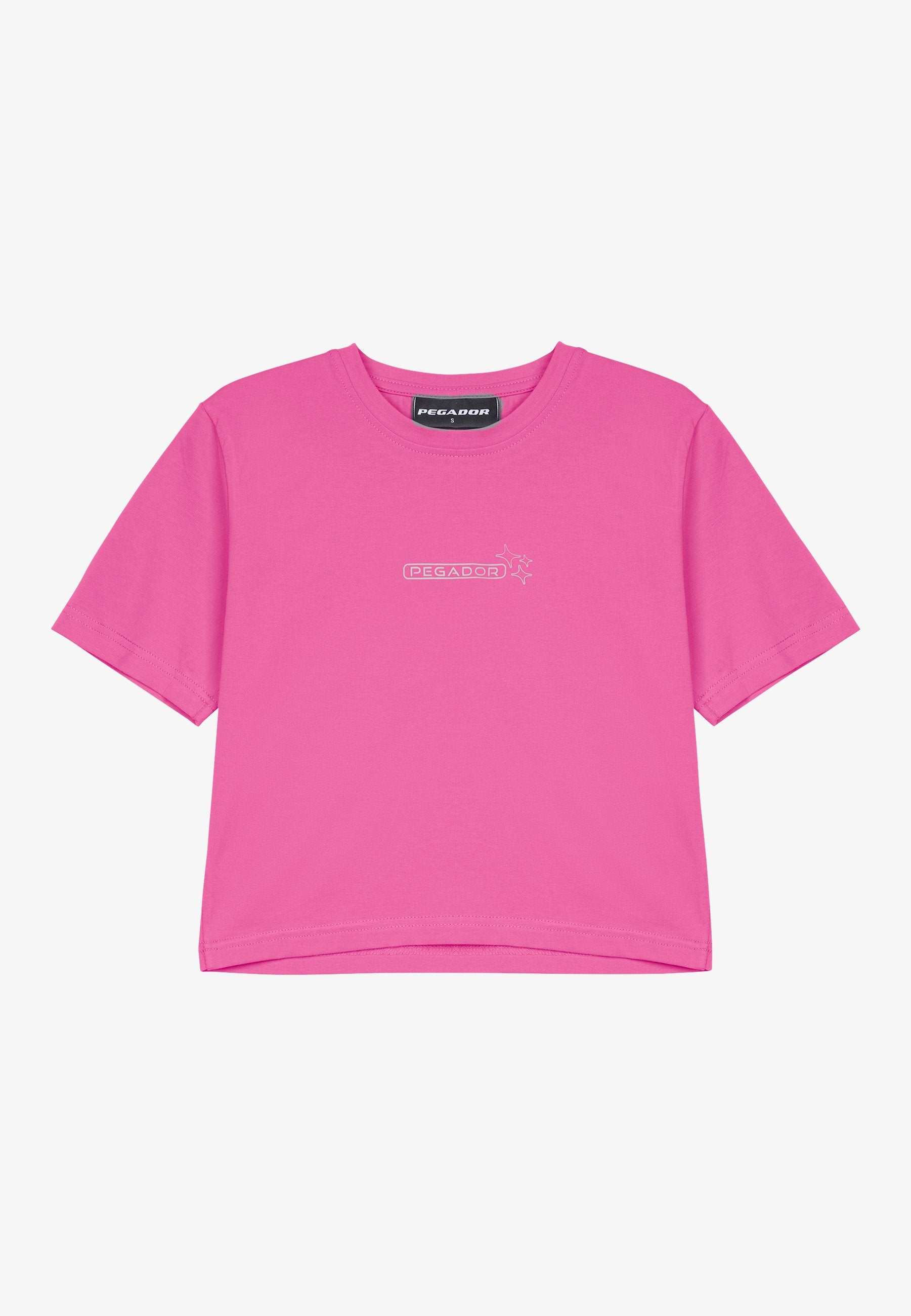 Rosa T-Shirt mit kurzen Ärmeln aus Baumwolle und rundem Ausschnitt. Verfügt über ein kleines, in Weiß auf der Vorderseite aufgedrucktes "PEGADOR"-Logo.