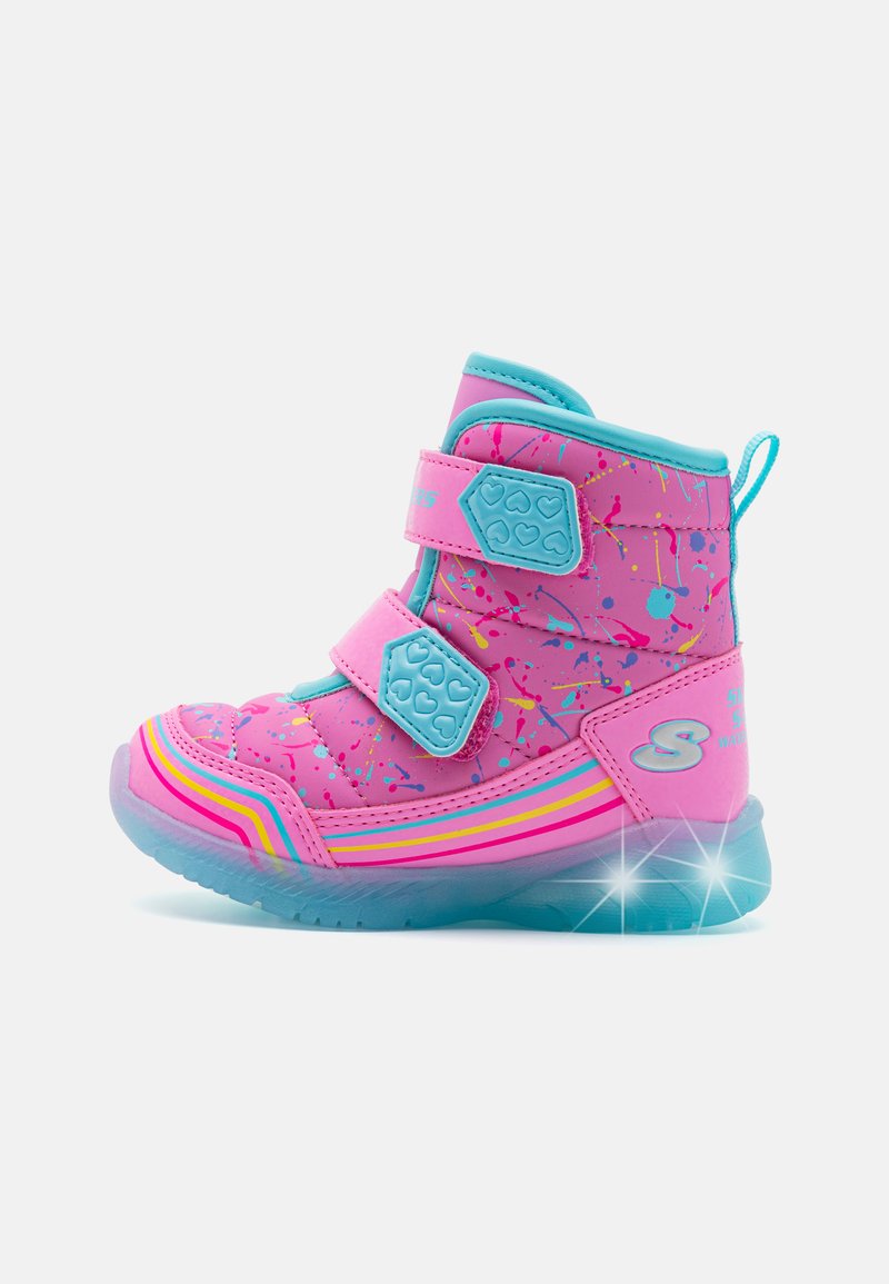 Rosa und blaue Kinderstiefel mit zwei Klettverschlüssen, Spritzmuster, reflektierenden Akzenten und einer durchsichtigen blauen Sohle.