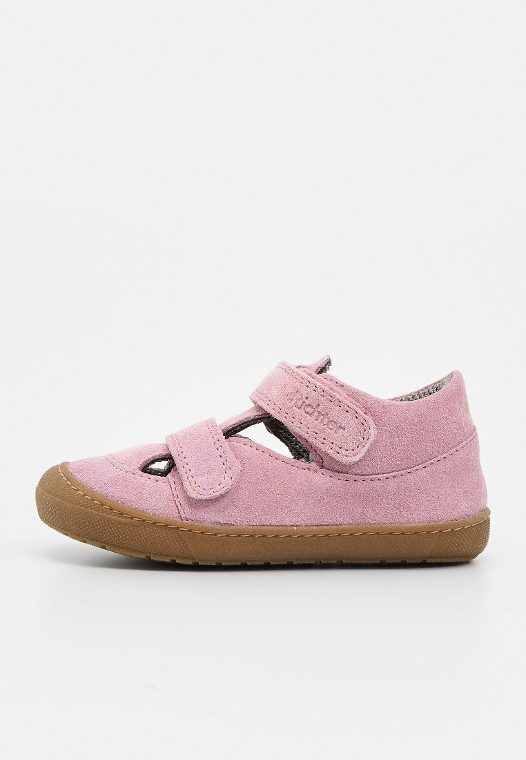 Rosa Wildleder-Kleinkindschuh mit zwei verstellbaren Klettverschlüssen und brauner Gummisohle, seitlich auf weißem Hintergrund abgebildet.