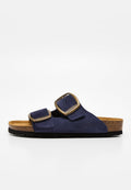 Marineblaue Wildleder-Sandale mit zwei verstellbaren bronzefarbenen Schnallen, Kork-Fußbett, schwarzer Sohle und offenem Zeh-Design.