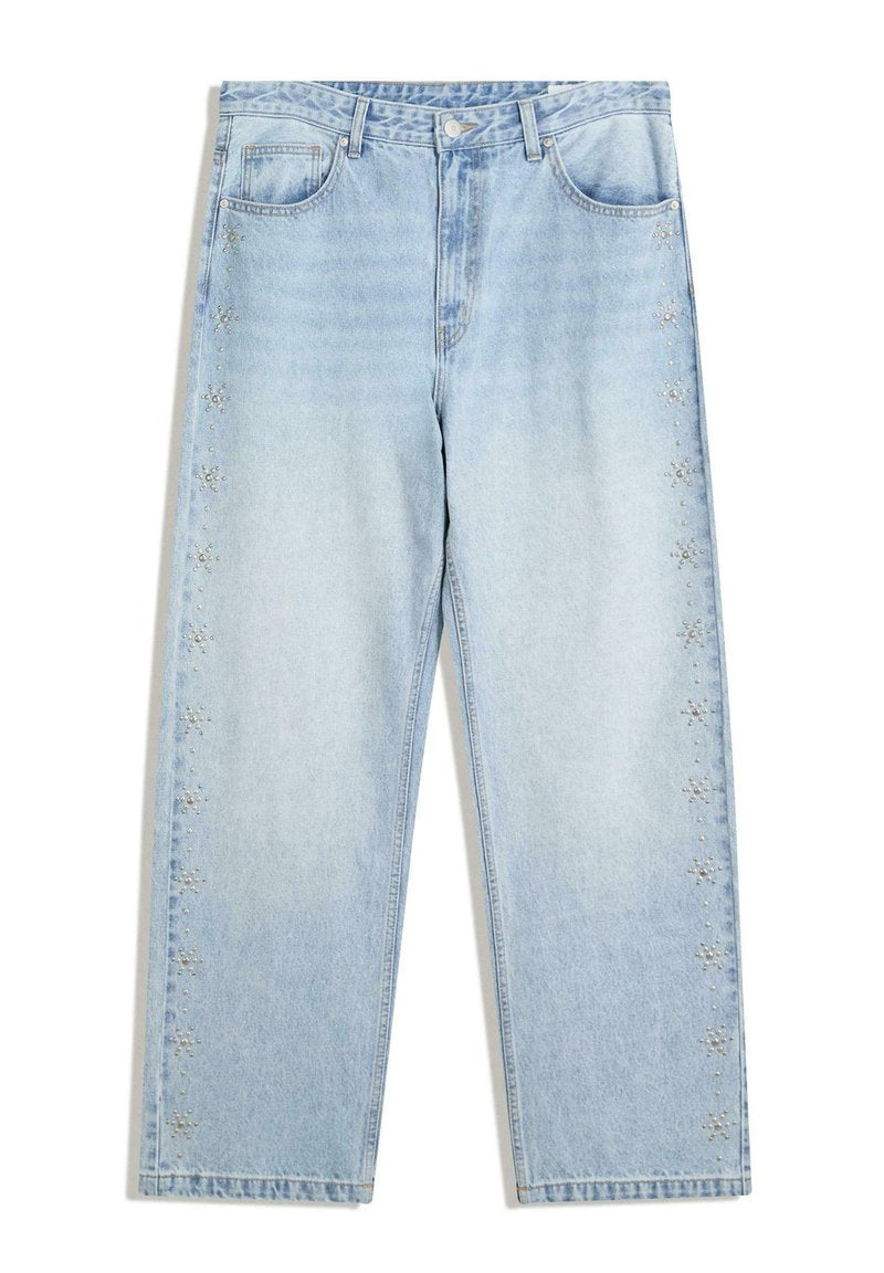 Hellblaue Denim-Jeans mit weitem Schnitt, verziert mit silbernen Nieten entlang der Seiten und traditionellem Fünf-Taschen-Design.
