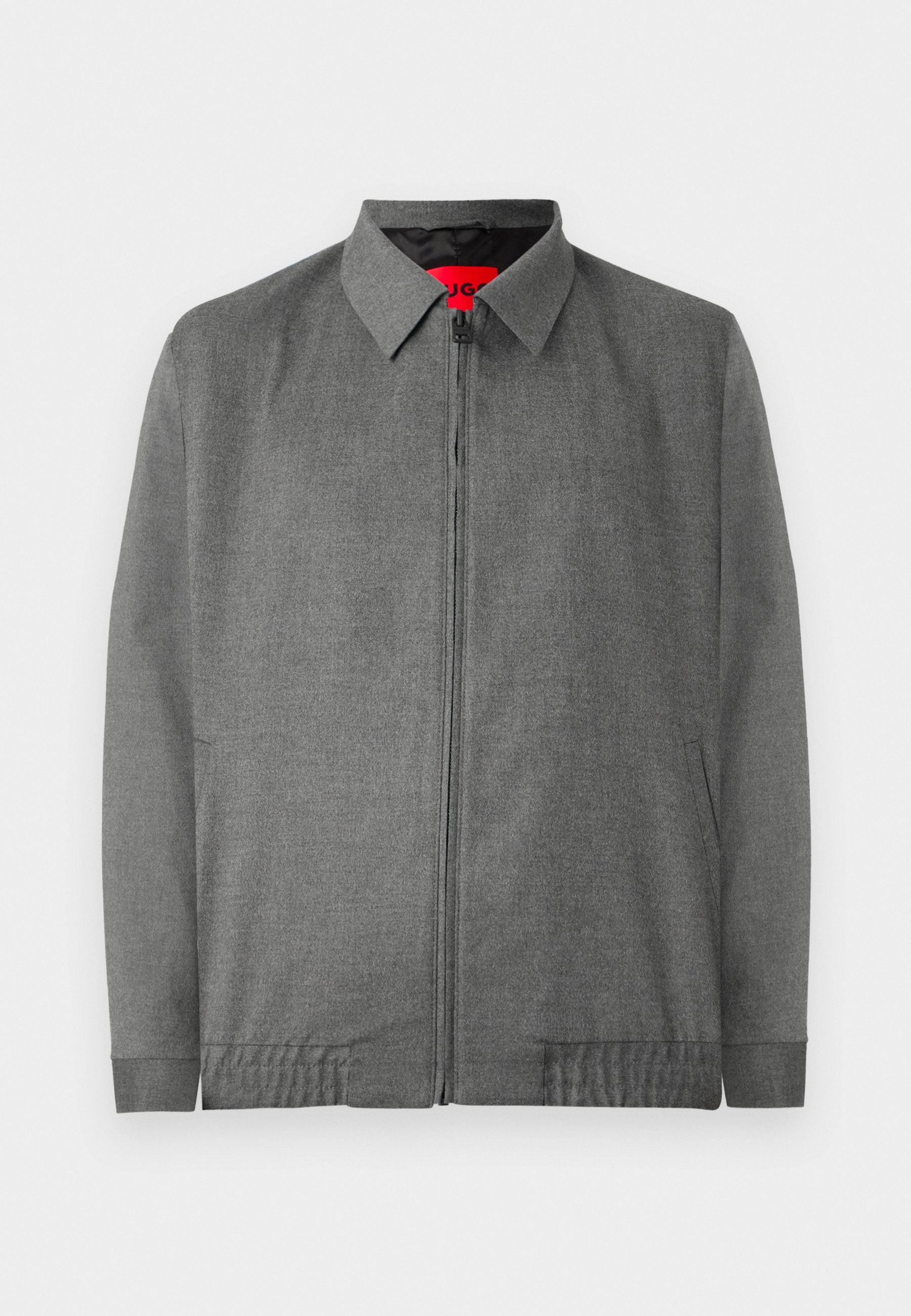 GrauJacke mit kragenförmigem Ausschnitt, vorderem Reißverschluss und Seitentaschen. Aus einem strukturierten Stoff mit elastischen Bündchen.