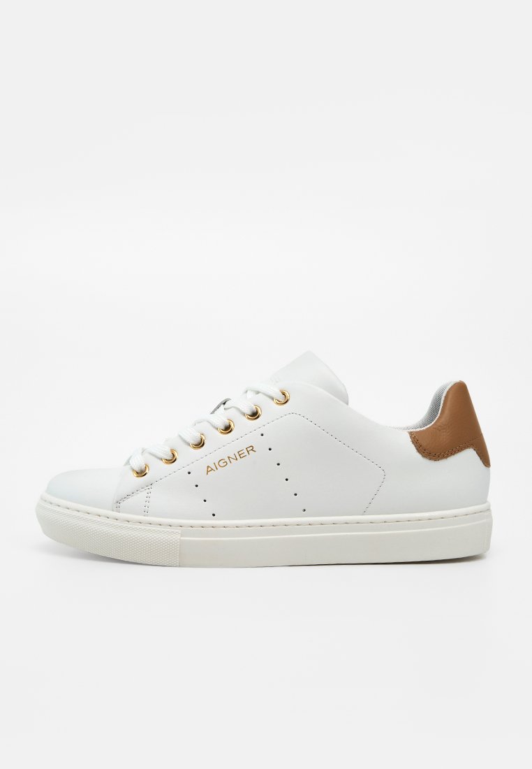 Weißer Ledersneaker mit goldenen Ösen und Branding, braunem Fersenpatch, weißer Sohle und Schnürdesign.