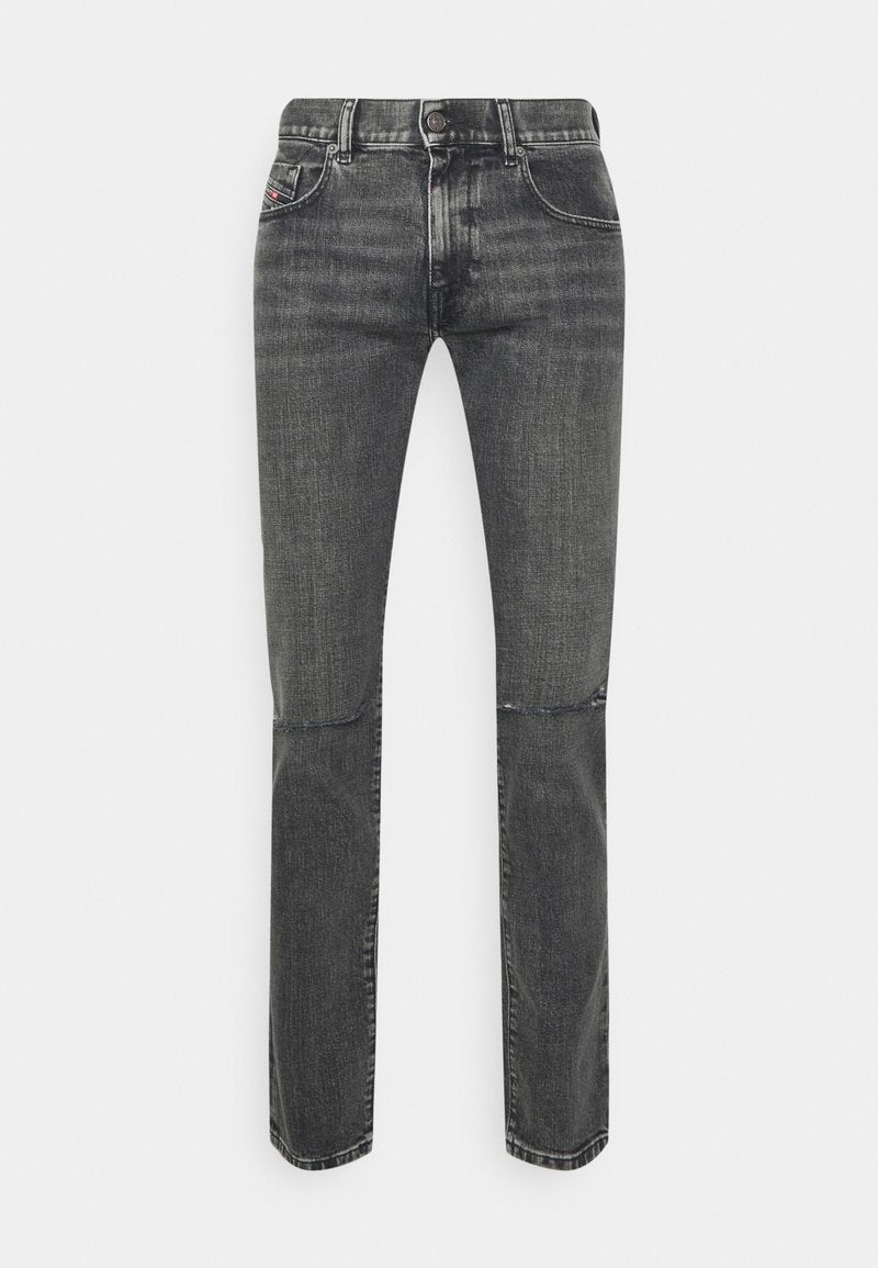 Graue Denim-Jeans mit geradem Bein, Fünf-Taschen-Design und subtiler Ausbleichung; metallene Knopf- und Nähakzente betonen das Material.