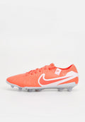 Leuchtend orangefarbener Fußballschuh mit weißen Akzenten, ausgestattet mit einem strukturierten Obermaterial, Schnürverschluss und einer leichten Sohle mit mehreren Stollen für besseren Halt.