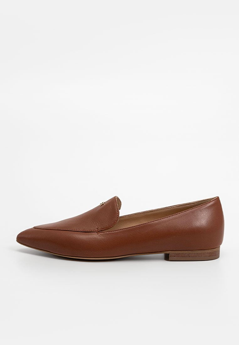 Braune Leder-Loafers mit spitz zulaufender Zehenpartie, flachem Absatz und minimalistischen Akzenten am Obermaterial. Glatte Textur und klassische Silhouette.