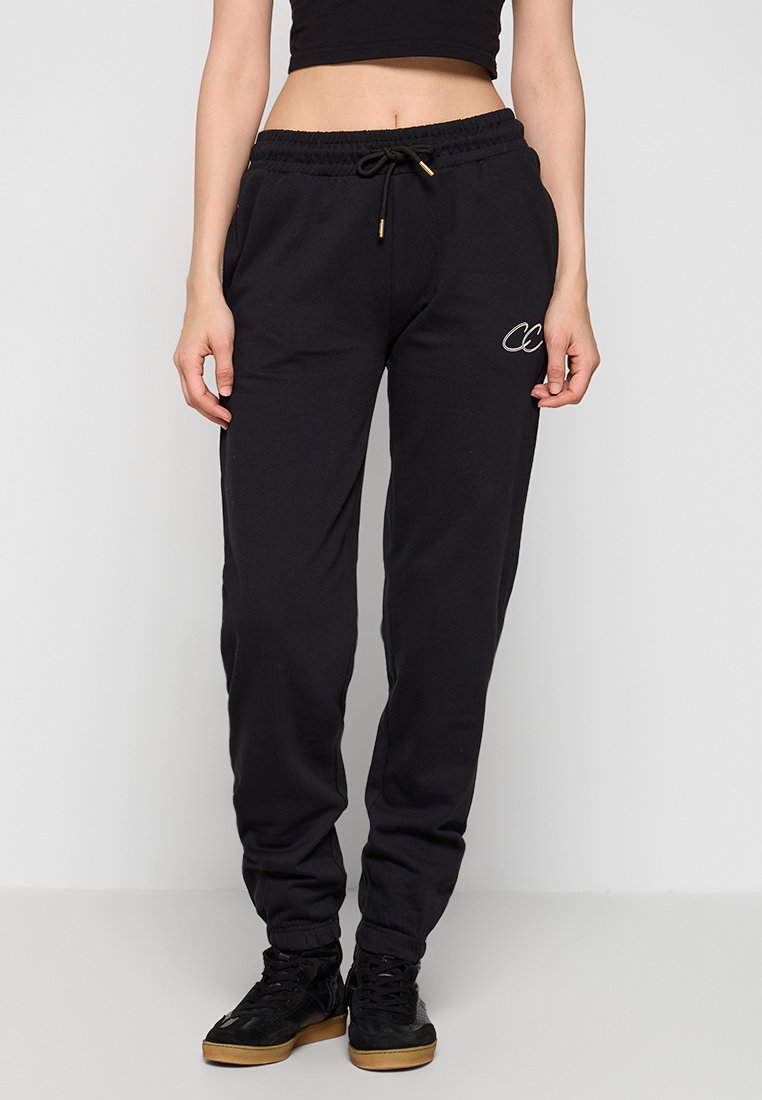 Schwarze Jogginghose aus weichem Stoff, mit einem Kordelzugbund, Bündchen an den Knöcheln und einem kleinen gestickten Logo auf der linken Seite.