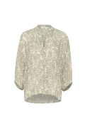 Leichte, beige Bluse mit einem subtilen grauen abstrakten Muster, V-Ausschnitt, Dreiviertelärmel und abgerundetem Saum. Weicher, strukturierter Stoff.
