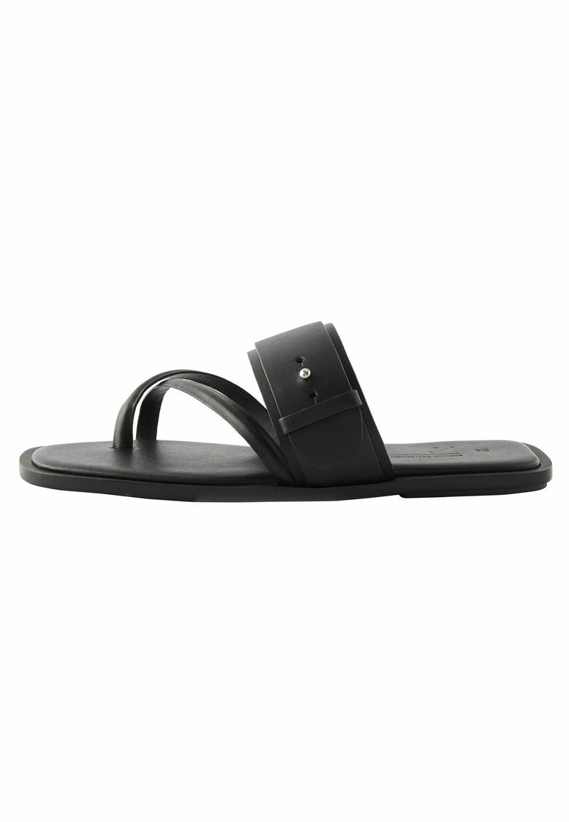 Schwarze flache Sandalen mit minimalistischer Gestaltung, die zwei überkreuzte Riemen und einen breiten Knöchelriemen mit Druckverschluss aufweisen. Glatte Oberfläche, Gummisohle.
