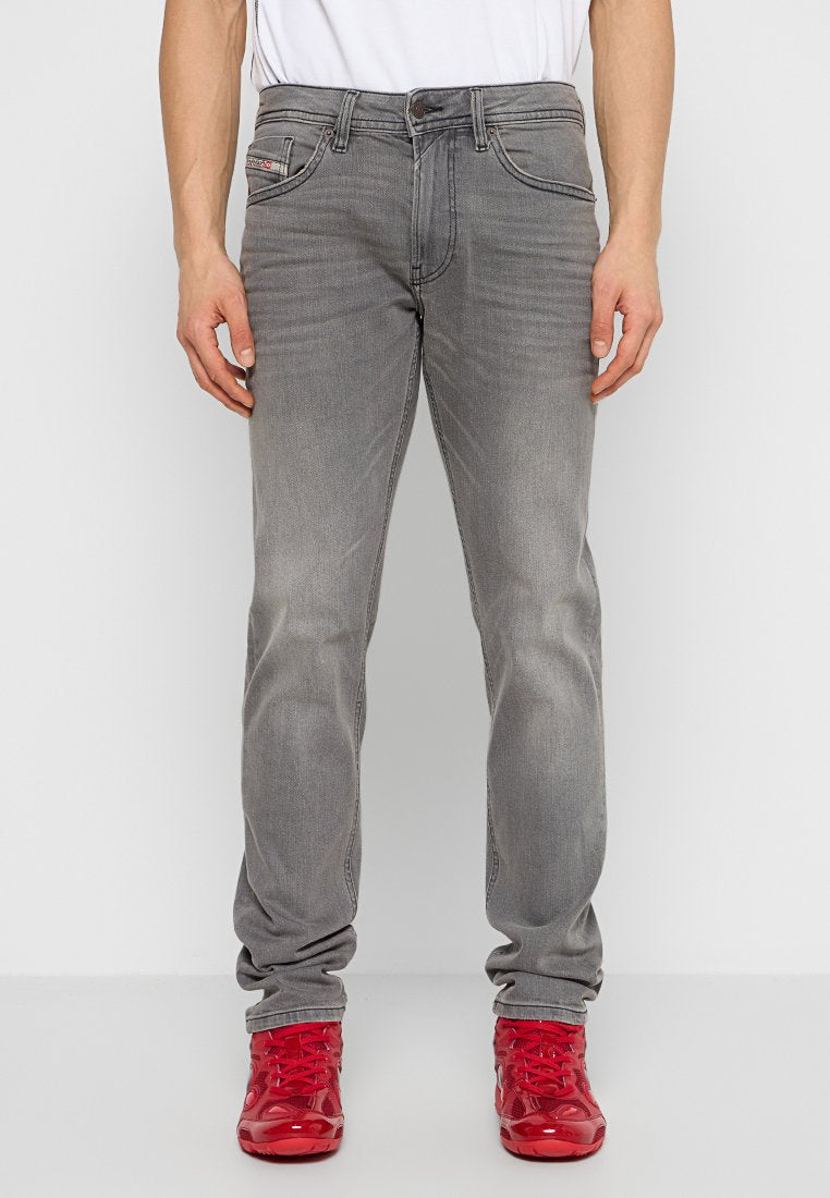 Graue Denim-Jeans mit geradem Schnitt, ausgestattet mit fünf Taschen und dezentem Verblassen. Abgeschlossen mit einem Metallknopf und einem Reißverschluss.