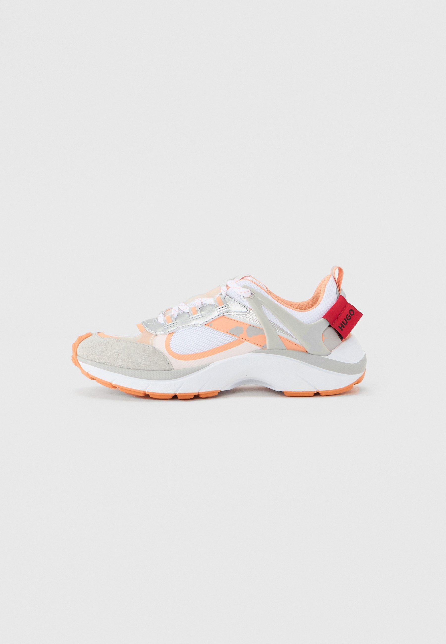 Sneaker mit einer Mischung aus weißem Mesh, grauem Wildleder und orangefarbenen Akzenten. Das Design verfügt über einen gepolsterten Schaft, Schnürsenkel und ein auffälliges pinkfarbenes Markenschild.