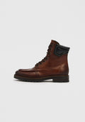 Brauner Leder-Stiefelette mit runder Spitze, Schnürdesign und schwarzen Lederakzenten. Profilsohle für besseren Halt.