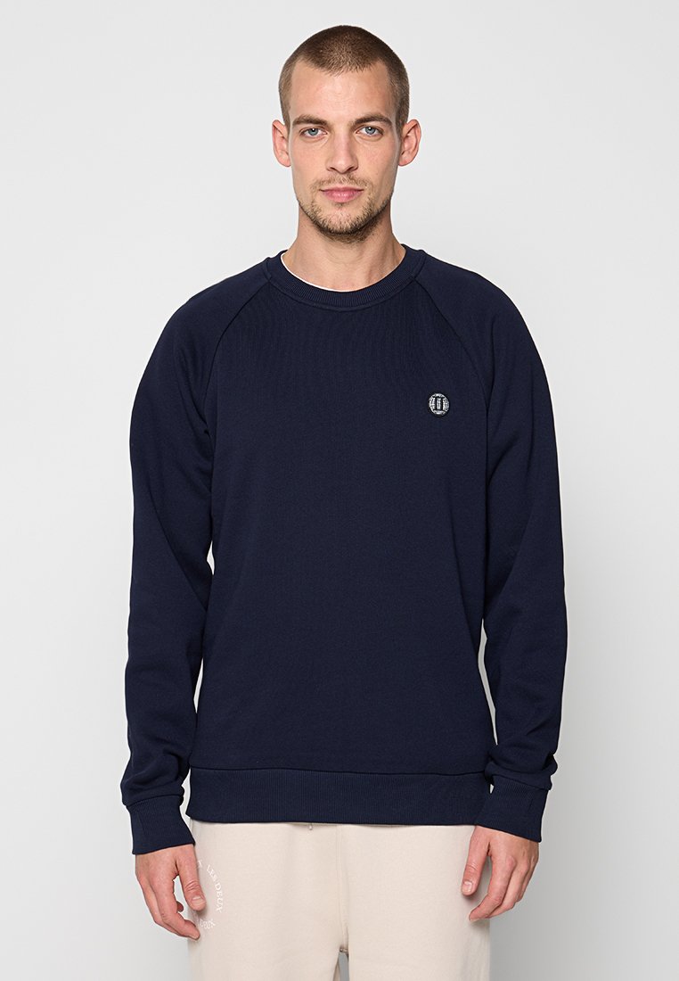 Marineblaue Sweatshirt mit geripptem Rundhalsausschnitt und Bündchen. Verfügt über Raglanärmel und ein kleines Logodetail auf der Brust. Weicher, strukturierten Stoff.