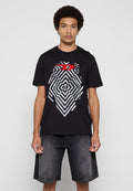Schwarzes Baumwoll-T-Shirt mit einem geometrischen silbernen und roten Grafikelement auf der Vorderseite. Kombiniert mit dunkelgrauen Denim-Shorts.