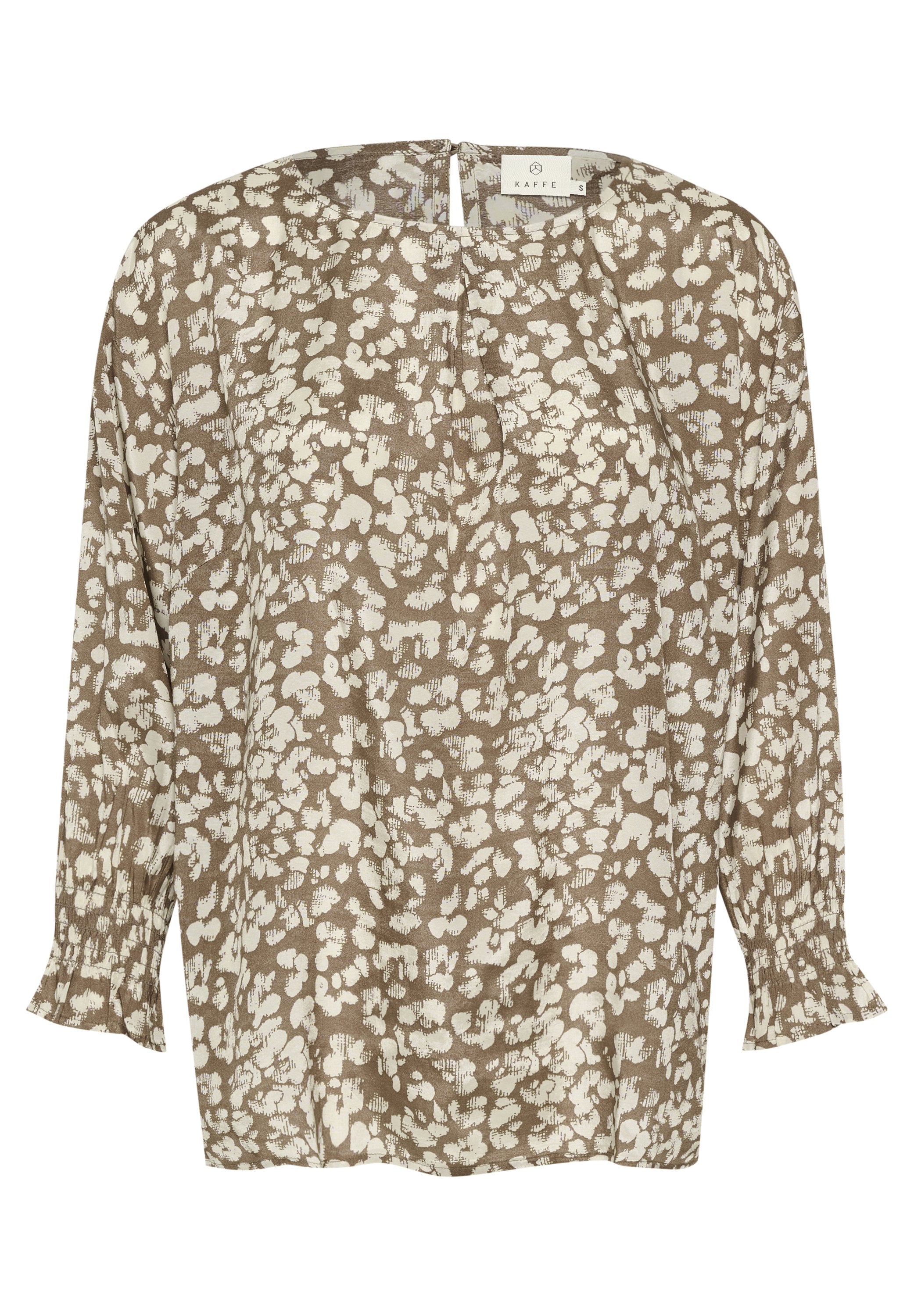 Braune Bluse mit weißem Blumenmuster, langen Ärmeln und gerafften Bündchen. Verfügt über einen Schlüsselaußenschluss am Rücken und einen lockeren, entspannten Schnitt.