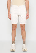 Weiße Baumwollshorts, enganliegendes Design, umgeschlagener Saum, vorderer Knopfverschluss, Seitentaschen, kombiniert mit beigen Turnschuhen und taupefarbenen Socken.