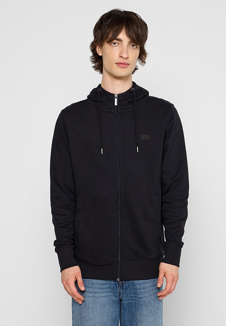 Schwarzer Reißverschluss-Hoodie mit einer Kapuze mit Kordelzug, Fronttaschen und gerippten Bündchen. Der Stoff wirkt weich und glatt und hat ein kleines Logo auf der Brust.
