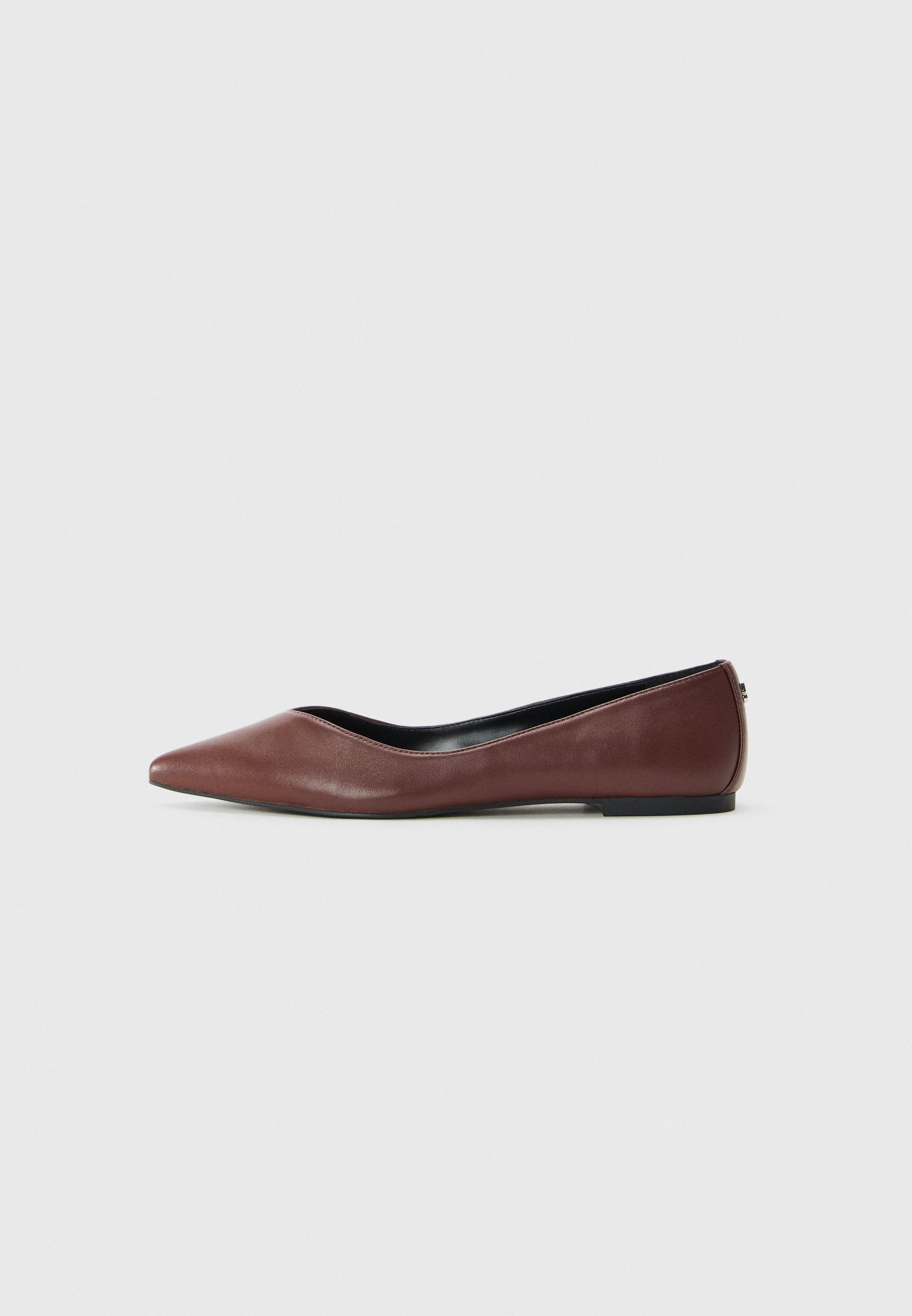 Braune, spitz zulaufende flache Lederschuhe mit schwarzer Sohle, seitlich auf weißem Hintergrund gezeigt.