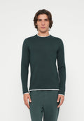 Dunkelgrünes Langarmshirt mit rundem Ausschnitt, versehen mit weißem Besatz am Kragen und an den Manschetten, gefertigt aus einem strukturierten Stoff.