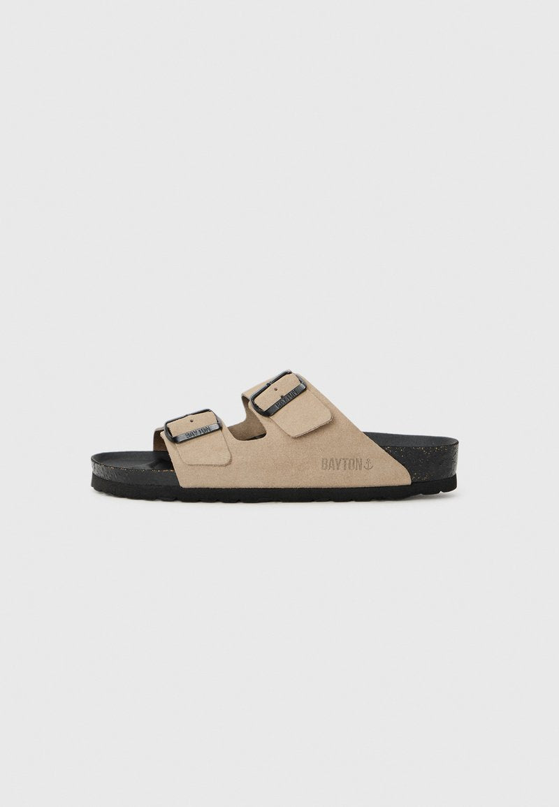 Beige Wildledersandalen ohne Riemen mit zwei verstellbaren Riemen und schwarzer Gummisohle. Mit geprägt Branding an der Seite.