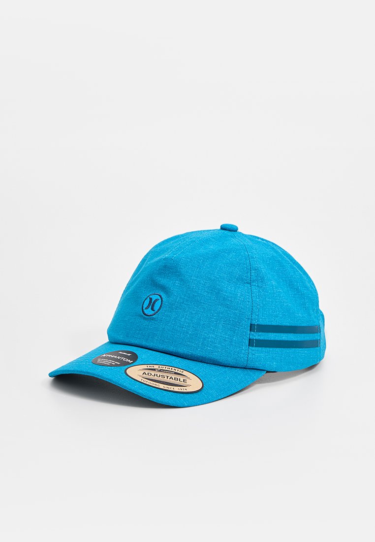 Helle blaue verstellbare Baseballmütze mit schwarzem Logo auf der Vorderseite und zwei reflektierenden Streifen an der Seite, die auf einer weißen Oberfläche liegt.