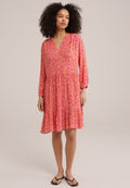 Rotes Kleid mit floralem Muster, V-Ausschnitt, langen Ärmeln und gestuftem Rock, aus leichtem Stoff gefertigt. Getragen mit schwarzen Ballerinas.