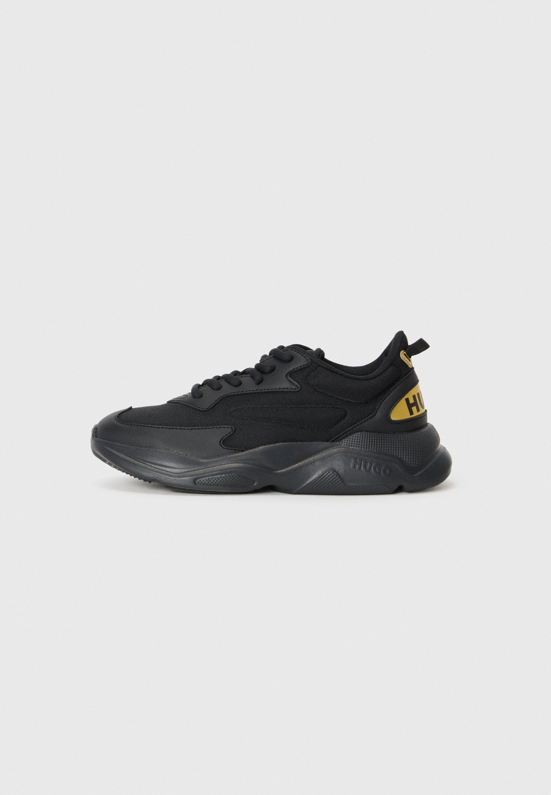 Schwarze Sneakers mit Textil-Obermaterial, gepolsterter Sohle und gelbem Logo. Verfügt über ein Schnürdesign und eine Zuglasche an der Ferse für ein einfaches Anziehen.