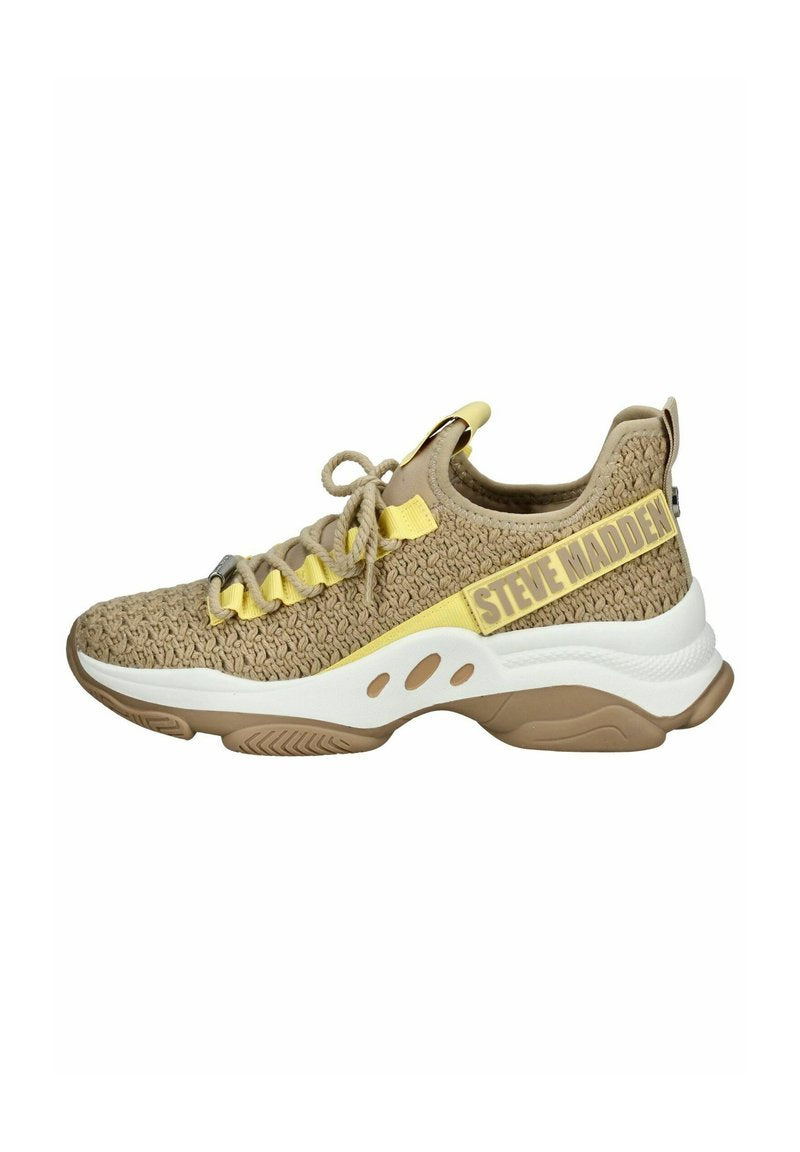 Beige gestrickter Sportschuh mit gelben Akzenten, ausgestattet mit einem Schnürdesign, einer gepolsterten Sohle und einem Logo-Riemen an der Seite.
