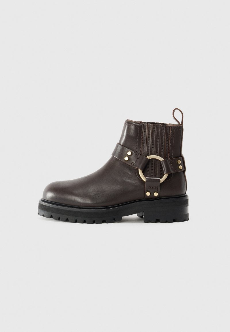 Braune Leder-Ankle-Boots mit elastischen Seitenpaneelen, goldfarbenem Ringakzent und robuster schwarzer Sohle. Verfügt über eine Brogue-Verzierung im oberen Bereich.