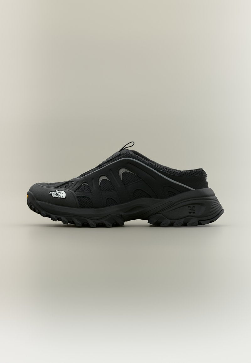 Schwarzer Hiking-Schlupfschuh mit robustem Profil, Mesh-Einsätzen und "The North Face"-Logo an der Spitze, vor neutralem Hintergrund.