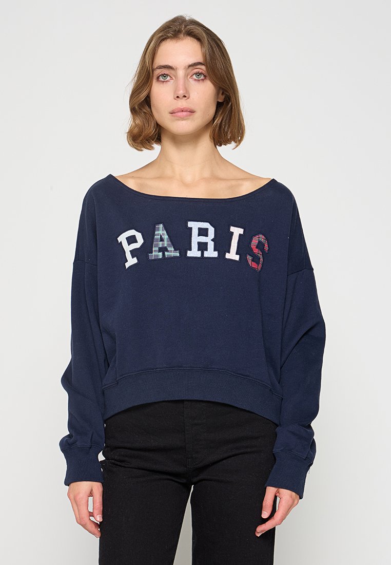 Marineblaues, kurzes Sweatshirt mit Fledermausärmeln, das "PARIS" in mehrtexturierten Buchstaben zeigt. Glattes Baumwollmaterial mit lässigem Schnitt.