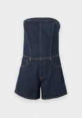 Jeansfarbener trägerloser Jumpsuit mit tailliertem Oberteil, Shorts-Schnitt, Kontrastnähte und zwei Vorderaschen. Dunkelblaue Farbe und glatte Textur.