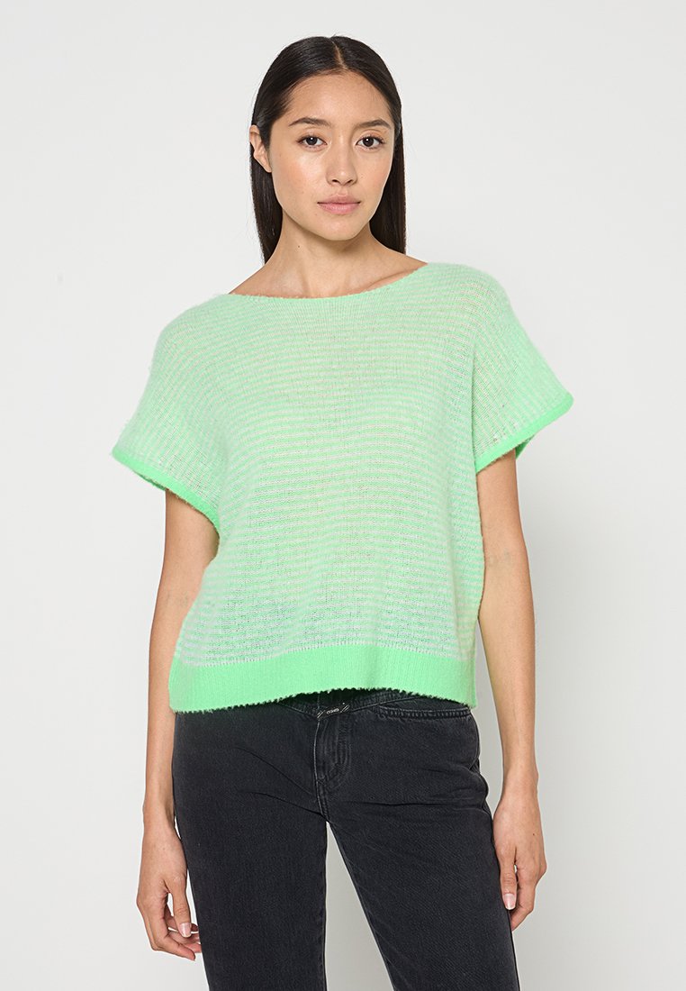 Helles grünes Kurzarm-Pullover mit lockerer Passform, ausgestattet mit einem strukturierten Strickmuster und einem gerippten Saum. Tragen mit schwarzen Jeans.