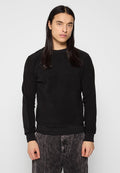 Schwarzer Sweatshirt mit weicher Textur und gerippten Bündchen. Verfügt über ein dezentes, geprägtes Logo auf der Vorderseite und einen lässigen Schnitt. Kombiniert mit gestreiften Hosen.