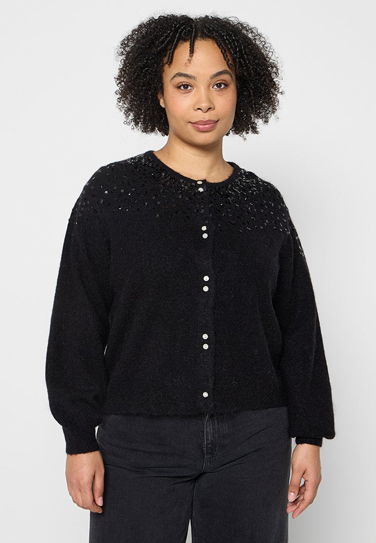 Schwarzer Cardigan aus weichem Material mit rundem Ausschnitt, dekorativen Pailletten an den Schultern und weißen Knöpfen vorne.