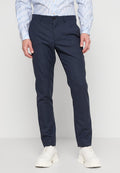 Marineblaue Hose mit dezentem Muster, aus strukturiertem Stoff gefertigt. Verfügt über einen Standardbund und eine schlanke Beinform, kombiniert mit weißen Schuhen.