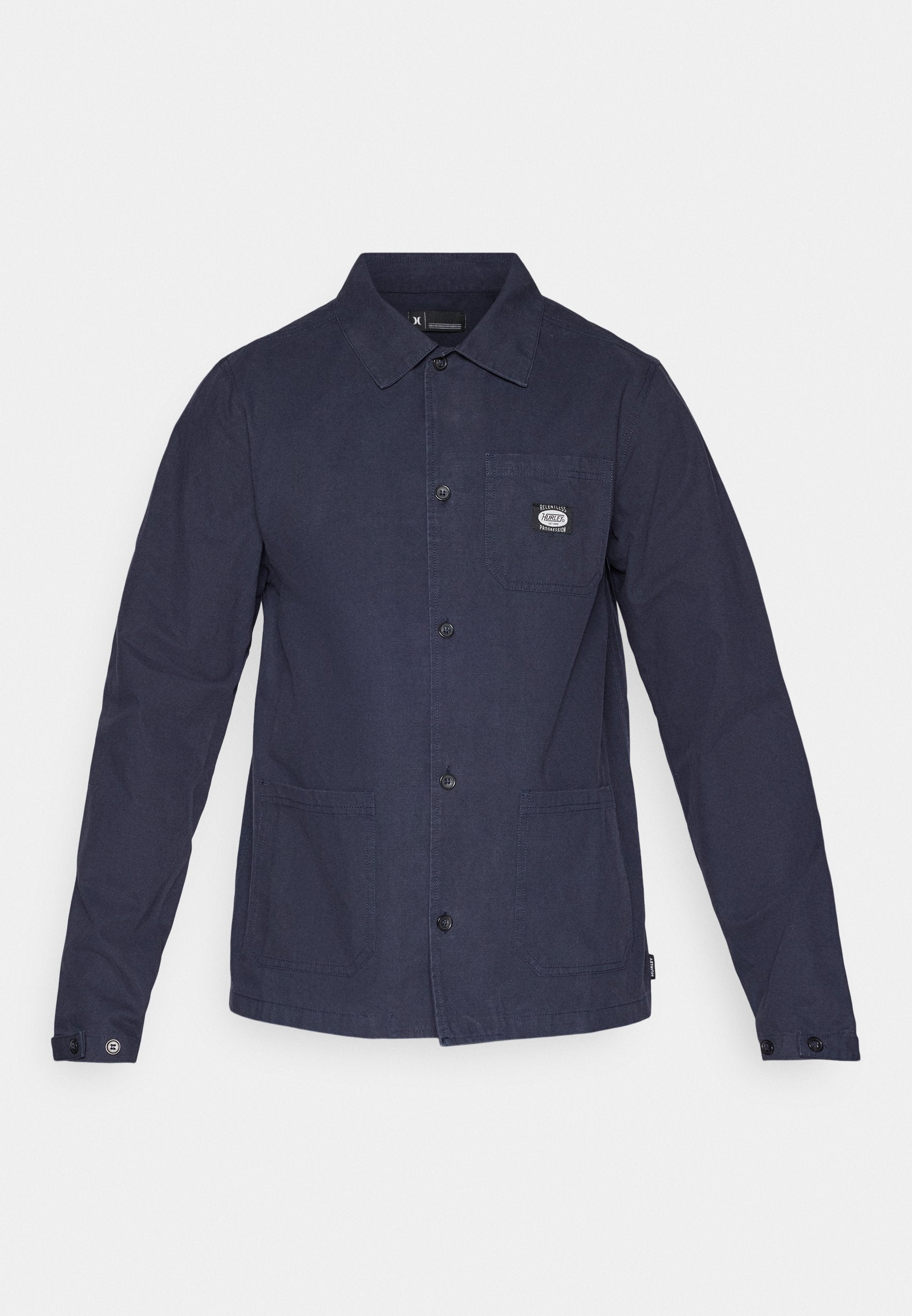 Marineblaue Hemdjacke aus strukturiertem Material, mit Kragen, Fronttaschen und einem kleinen Markenpatch auf der oberen linken Seite.