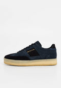 Dunkelblaue Wildledersneaker mit schwarzem Wildlederpaneel, goldenem Logodetail und Gummisohle. Abgerundete Form und leichtes Design.