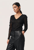 Schwarzes, transparentes Langarmshirt mit strukturierten vertikalen Streifen, einem V-Ausschnitt und figurschmeichelndem Schnitt, kombiniert mit hochgeschnittenen schwarzen Lederhosen.