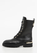 Schwarze Lederkampfstiefel mit goldenen Ösen, schwarzen Schnürsenkeln, einer dicken Profilsohle und einem goldenen metallischen Akzent an der Ferse.