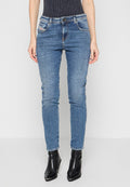 Blaue Skinny-Jeans aus Denim mit mittlerer Taille, fünf Taschen, sichtbaren Nähten und einem leicht abgenutzten Finish, kombiniert mit schwarzen Knöchelstiefeln.