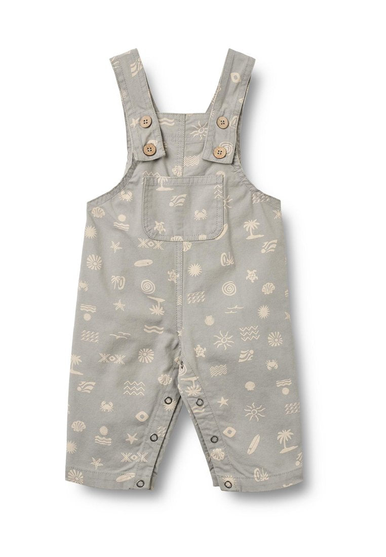 Graue Baumwolllatzhose mit weißen Mustern von Sonne, Wellen und Muscheln. Verfügt über Knopfträger, eine Fronttasche und Druckknöpfe an den Beinen.