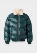 Grüne Puffjacke mit Reißverschluss vorne, Schafspelzkragen, gestepptem Muster, elastischen Bündchen und Saum sowie zwei Seitentaschen.