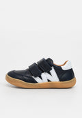 Marineblaue Ledersneaker mit weißen Akzenten, zwei Klettverschlüssen, Gummisohle und einer runden Zehenform. Mit einem sichtbaren Logo in Weiß.