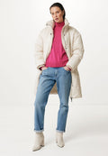 Beige Daunenjacke mit hohem Kragen, über einem knallpinken Rollkragenpullover getragen. Dazu passen hellblaue Straight-Leg-Jeans und cremefarbene Stiefeletten.